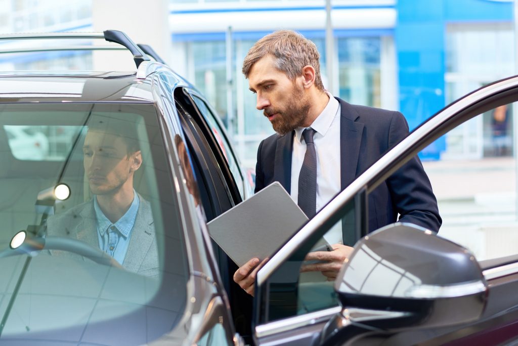 Man Testing New Car in Showroom